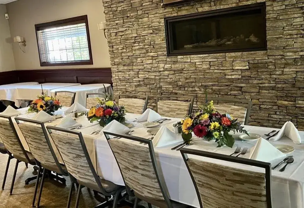 Banquet table with fresh flowers beside the stone wall